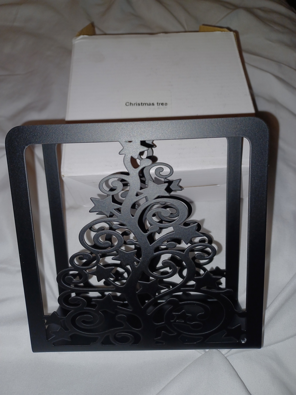 black metal napkin holder featuring an intricate, cut-out Christmas tree design